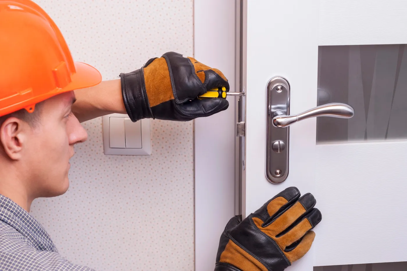 Serrurier indépendant posant une serrure sur une porte de maison à Montesson (78360)